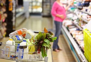 Pregnant mom chooses healthy items in the grocery store.