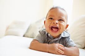 Baby is laughing a big laugh.